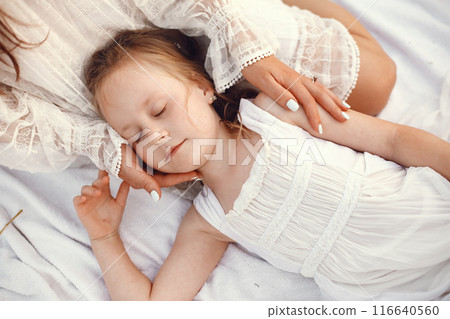 Family in a summer field. Sensual photo. Cute little girl. Woman in a white dress. 116640560