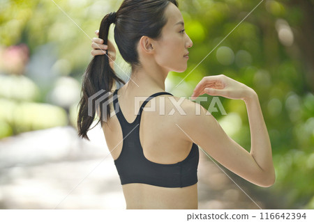 穿著運動服在綠地慢跑的年輕女子 穿著運動服在綠地慢跑的年輕女子 116642394