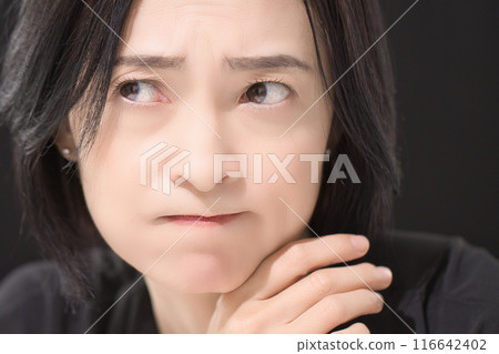 Middle-aged woman with a troubled expression Middle-aged woman with a troubled expression 116642402