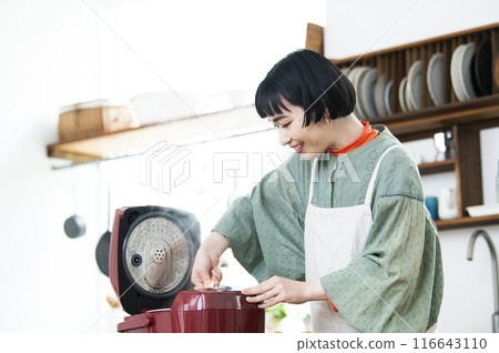 一名婦女正在攪拌剛煮好的米飯 116643110