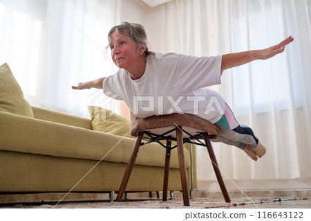 Senior caucasian woman doing yoga at home on chair 116643122