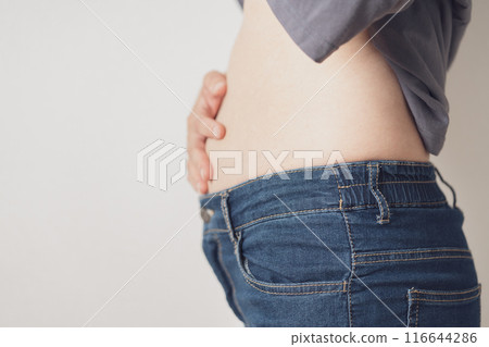 A woman putting her hands on her stomach 116644286
