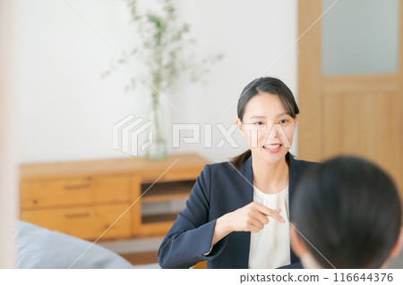 A woman in a suit talking to her parents at home A woman in a suit talking to her parents at home 116644376