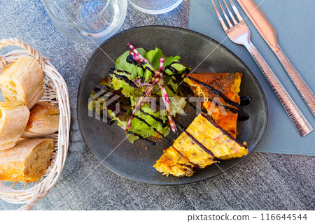 Traditional Spanish potato chorizo tortillas with lettuce closeup Traditional Spanish potato chorizo tortillas with lettuce closeup 116644544