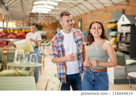 Friendly couple looking for comfortable furniture in garden store Friendly couple looking for comfortable furniture in garden store 116644614