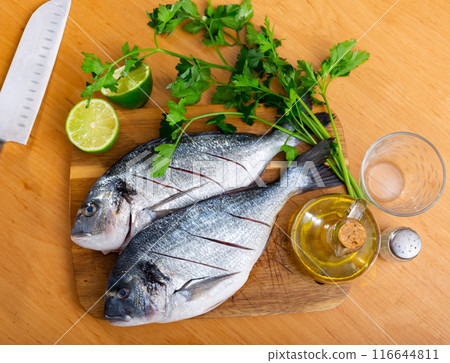 Two breams laying on cutting board with lime and parsley 116644811