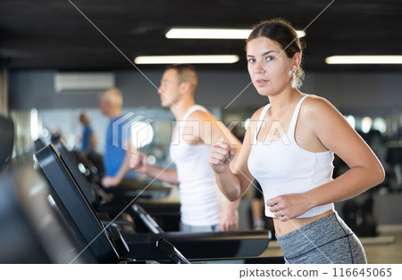 Girl walk on treadmill in gym. Healthy lifestyle, extensive training Girl walk on treadmill in gym. Healthy lifestyle, extensive training 116645065