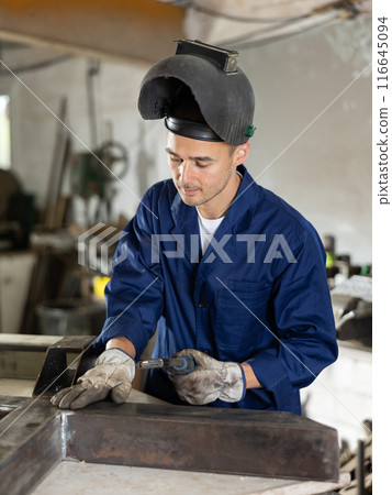 During manufacture of product, man employee works with welding machine During manufacture of product, man employee works with welding machine 116645094