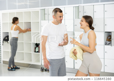 Cheerful man talking with female friend in locker room of climbing gym 116645160