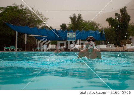 Boy with glasses swims in the pool Boy with glasses swims in the pool 116645766