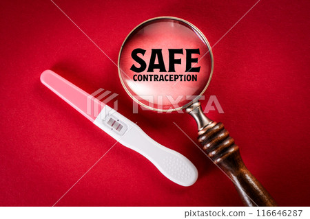 Safe Contraception Concept. Positive pregnancy test and magnifying glass on red background 116646287