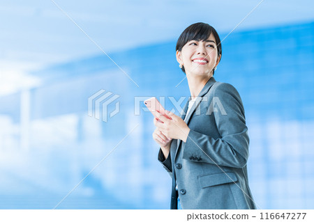 A business person operating a smartphone. A business person operating a smartphone. 116647277