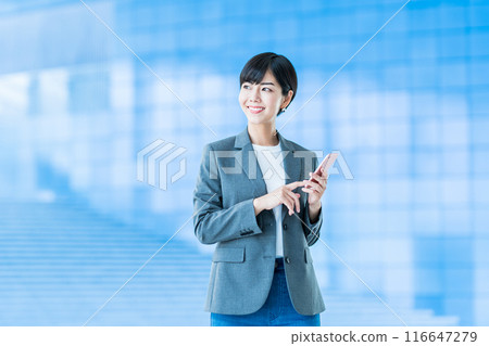 A business person operating a smartphone. A business person operating a smartphone. 116647279