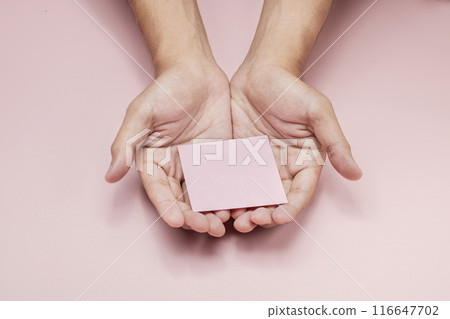 A human hand holding a note on his palm 116647702