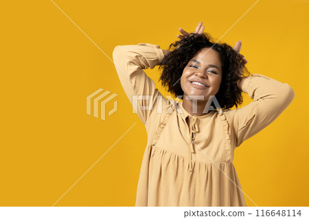 Young attractive African American woman dancing on yellow background Young attractive African American woman dancing on yellow background 116648114