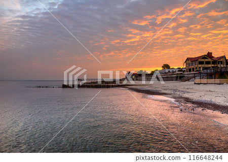 View of sand beach with wooden breakwaters on the Baltic Sea coast on sunrise in Zelenogradsk. Russia View of sand beach with wooden breakwaters on the Baltic Sea coast on sunrise in Zelenogradsk. Russia 116648244