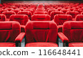 Rows of empty red theater seats in a darkened movie theater. 116648441
