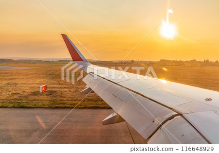 View on sunset and airplane wing from the inside 116648929