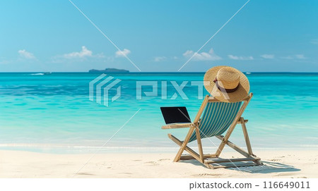 Beach scene with sunhat, deck chair, and laptop facing turquoise sea under clear blue sky, promoting work-life balance and relaxation. 116649011