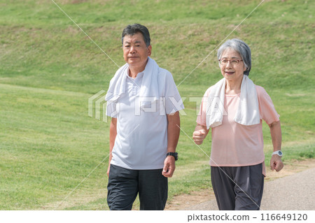 Elderly couple (senior, male and female) walking and aerobic exercise in the park 116649120