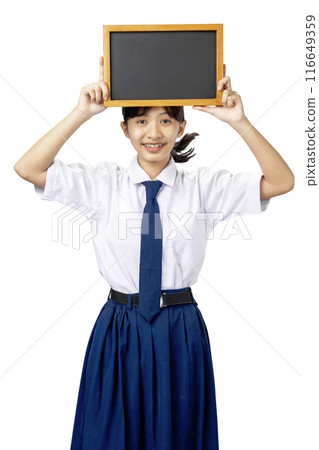 Portrait of an Asian Junior High School student girl in white and blue uniform standing while showing blank small blackboard Portrait of an Asian Junior High School student girl in white and blue uniform standing while showing blank small blackboard 116649359