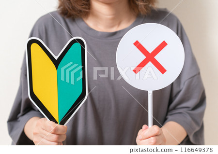 A woman holding a beginner's mark and an X plate A woman holding a beginner's mark and an X plate 116649378