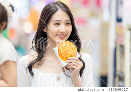 A young woman eating while sightseeing 116649617