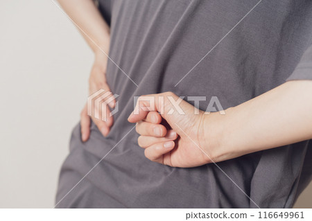 一個女人痛苦地把手放在腰上 一個女人痛苦地把手放在腰上 116649961