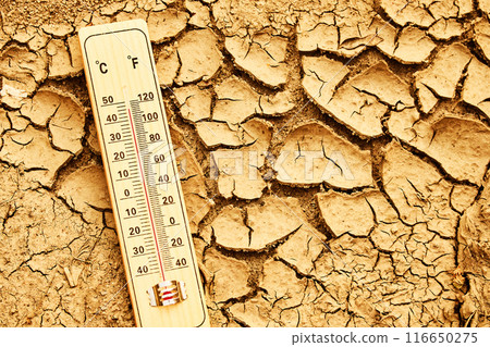Climate change concept. Thermometer on arid, cracked soil representing extreme heat and drought conditions. Climate change concept. Thermometer on arid, cracked soil representing extreme heat and drought conditions. 116650275