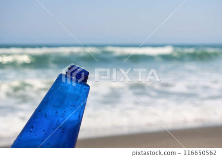 有波浪和藍色瓶子的沙灘 116650562