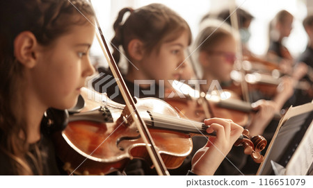 Youth Violin Ensemble. A close-up of young musicians playing violins 116651079