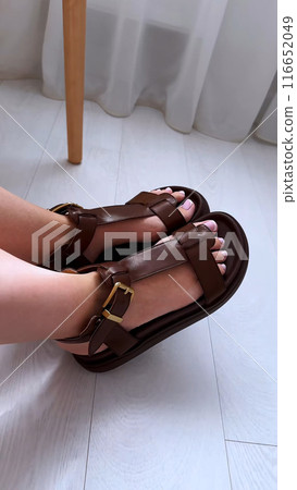 Women's toes with a beautiful pedicure in sandals. Women's toes with a beautiful pedicure in sandals. 116652049