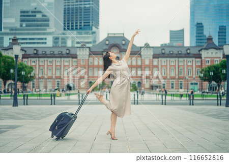 一位年輕女子拎著隨身行李去旅行，看起來很興奮。 116652816