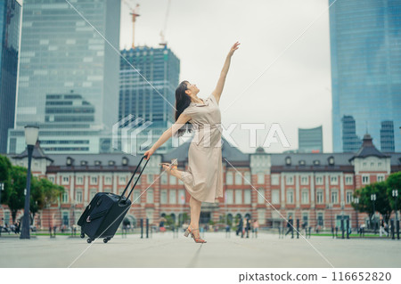 一位年輕女子拎著隨身行李去旅行，看起來很興奮。 116652820