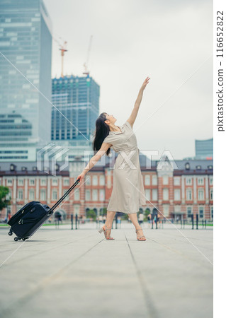 A young woman with a suitcase on a trip, looking excited A young woman with a suitcase on a trip, looking excited 116652822