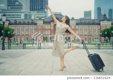 A young woman with a suitcase on a trip, looking excited A young woman with a suitcase on a trip, looking excited 116652824