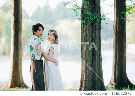 Bride and groom having pre-wedding photos while having a picnic Bride and groom having pre-wedding photos while having a picnic 116652872