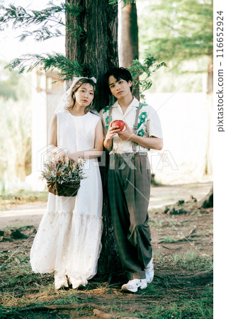 Bride and groom having pre-wedding photos while having a picnic Bride and groom having pre-wedding photos while having a picnic 116652924