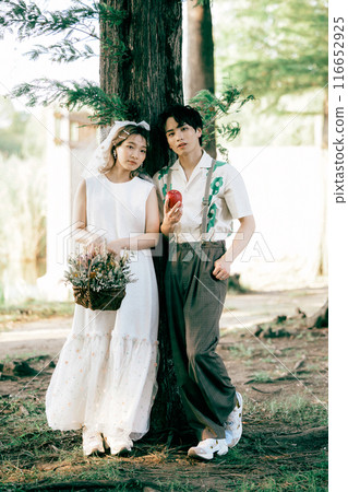 Bride and groom having pre-wedding photos while having a picnic 116652925