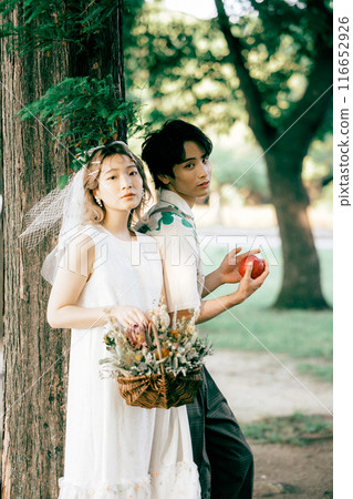 Bride and groom having pre-wedding photos while having a picnic Bride and groom having pre-wedding photos while having a picnic 116652926
