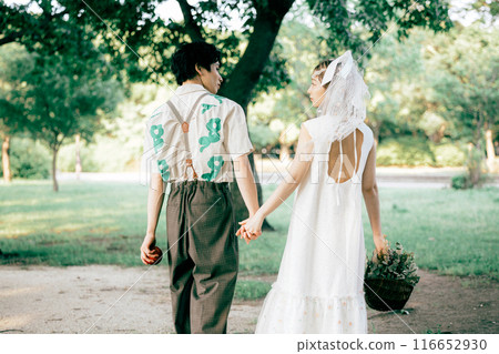 Bride and groom having pre-wedding photos while having a picnic Bride and groom having pre-wedding photos while having a picnic 116652930