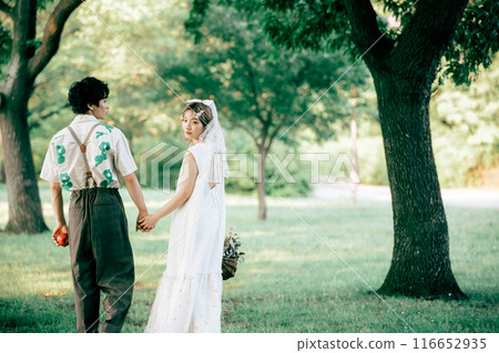 Bride and groom having pre-wedding photos while having a picnic Bride and groom having pre-wedding photos while having a picnic 116652935