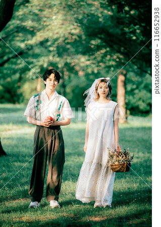 Bride and groom having pre-wedding photos while having a picnic 116652938