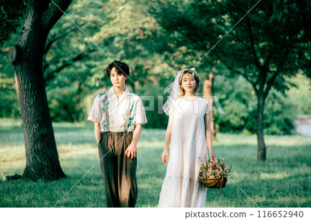 Bride and groom having pre-wedding photos while having a picnic Bride and groom having pre-wedding photos while having a picnic 116652940