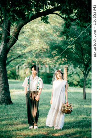 Bride and groom having pre-wedding photos while having a picnic Bride and groom having pre-wedding photos while having a picnic 116652942