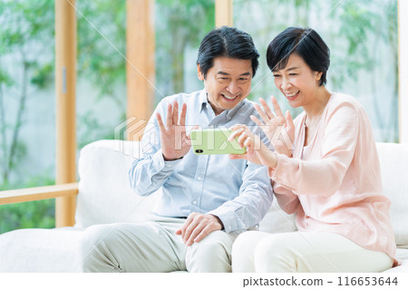 A middle-aged couple relaxing in the living room 116653644