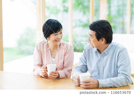 A middle-aged couple relaxing in the living room 116653670