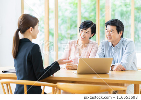 A middle-aged couple consulting with a consultant A middle-aged couple consulting with a consultant 116653698