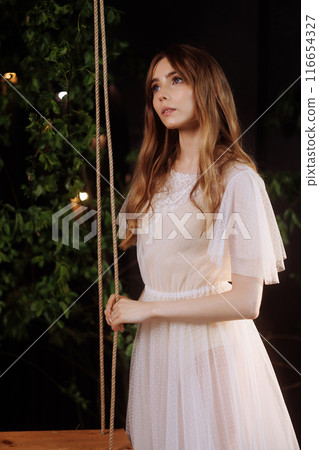 Elegant woman on wooden swing. Elegant woman on wooden swing. 116654327