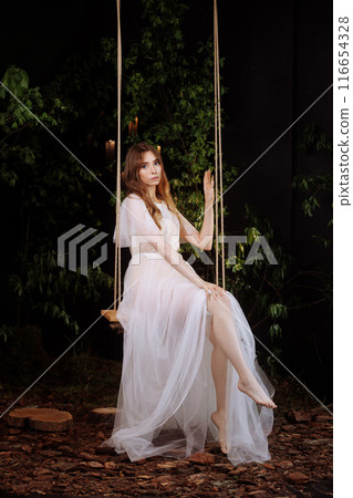 Elegant woman on wooden swing. Elegant woman on wooden swing. 116654328